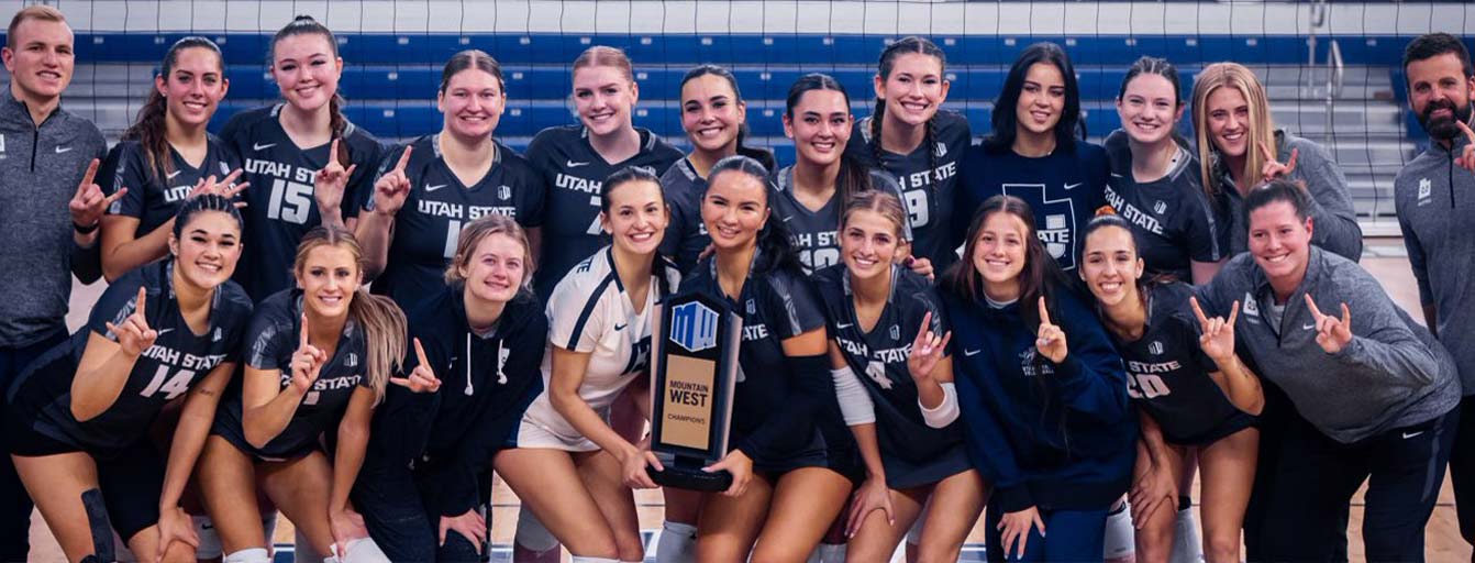 Women's volleyball team posing with trophy